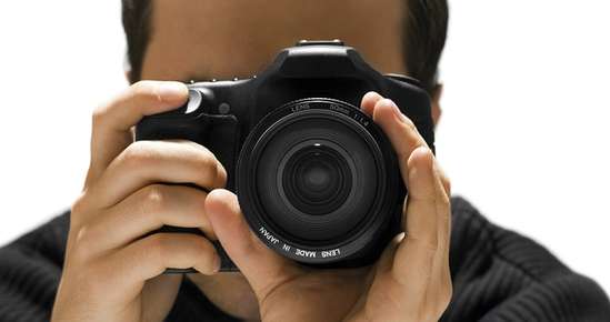 Image of a man focusing a digital camera.