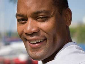 Image of a man half-blinking and smiling.