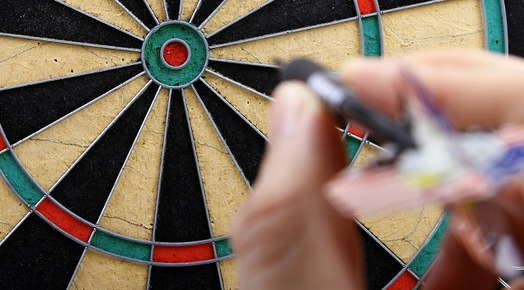hand aiming to throw dart