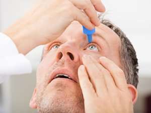 Image of a man using eyedrops.